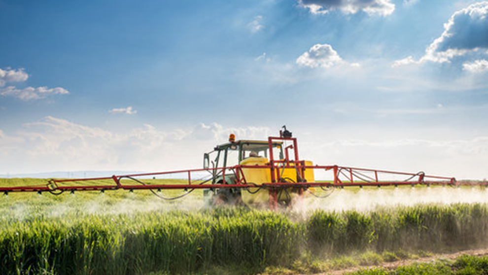 Ein Traktor bringt Pflanzenschutzmittel aus