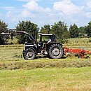 Traktor beim Heuwenden und -schwaden