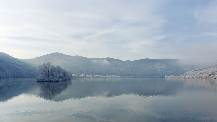 Das Vogelschutzgebiet Stausee bei Affoldern mit Blick auf den nebelverhangenen See im Winter.